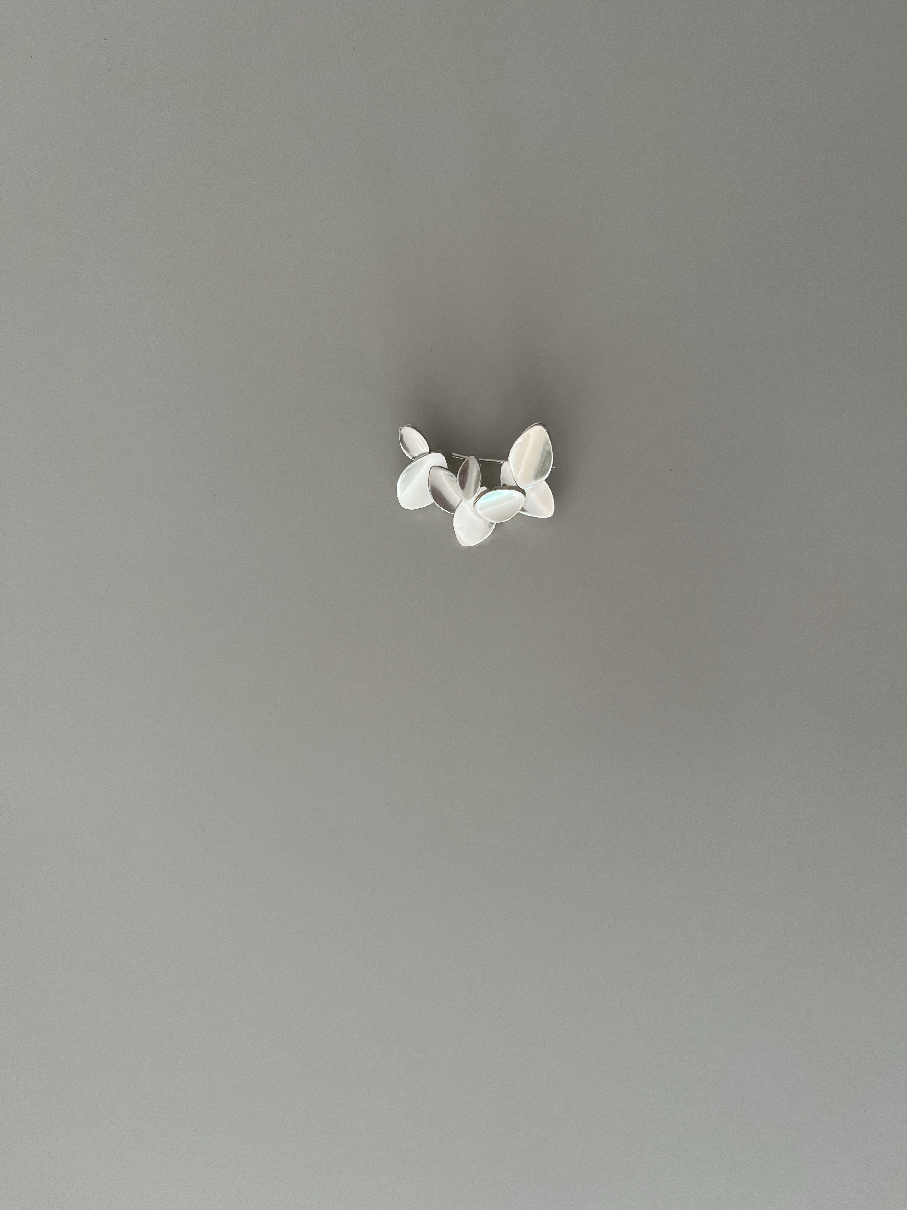 Silver floral ring on a neutral background